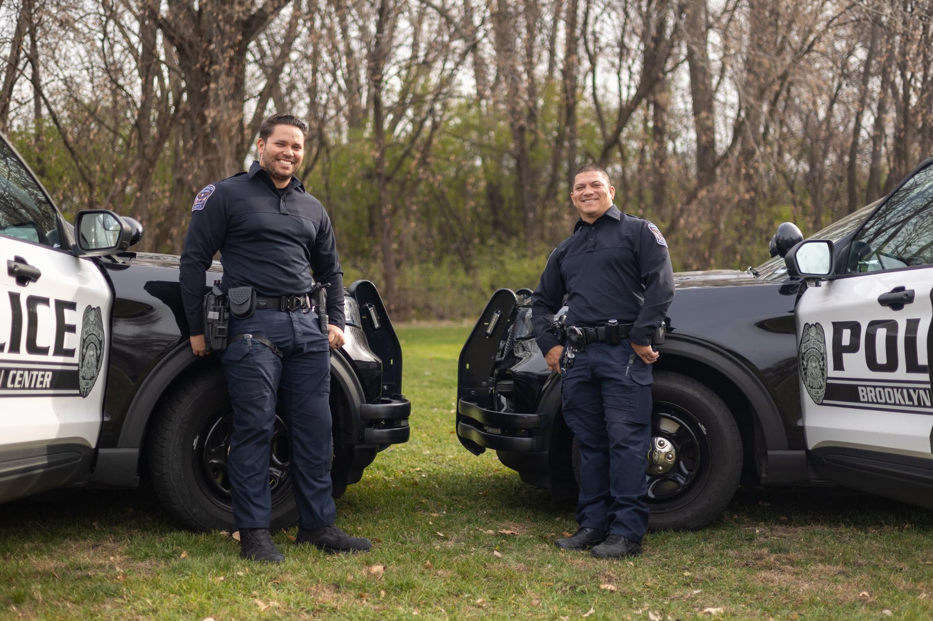 Martinez and Lausen Standing in front of Vehicles